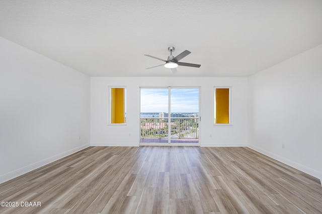 spare room with ceiling fan and light wood-type flooring