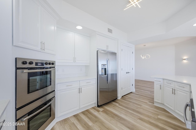 kitchen with light hardwood / wood-style flooring, stainless steel appliances, and white cabinets