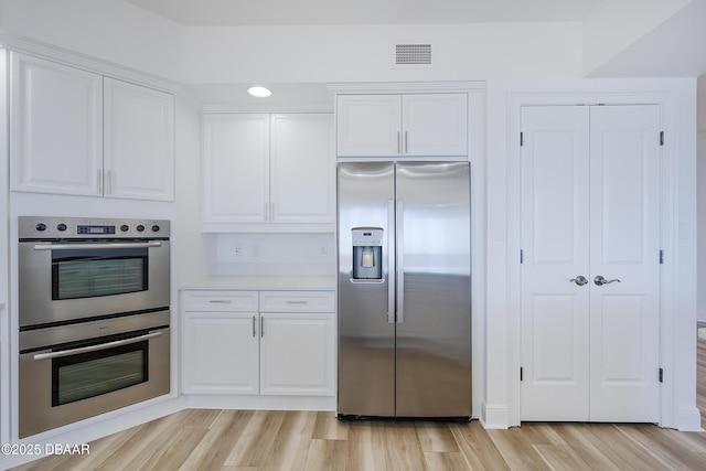 kitchen with white cabinetry, light hardwood / wood-style floors, and appliances with stainless steel finishes