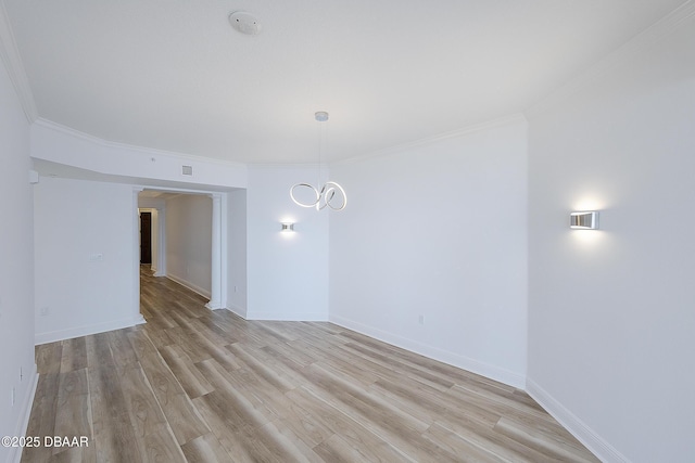 spare room featuring crown molding and light wood-type flooring