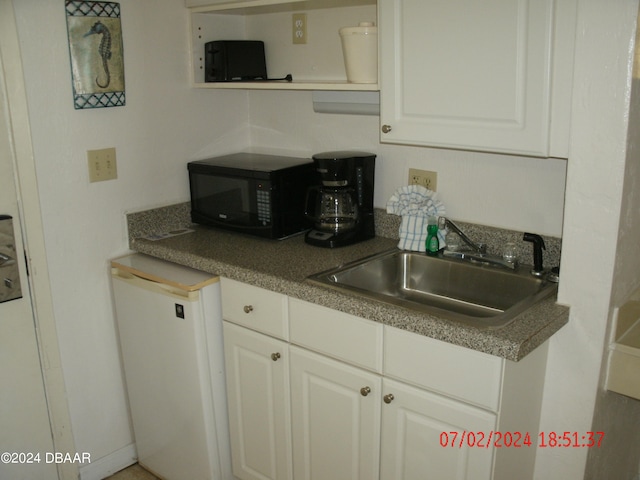 kitchen featuring white cabinets, white dishwasher, and sink