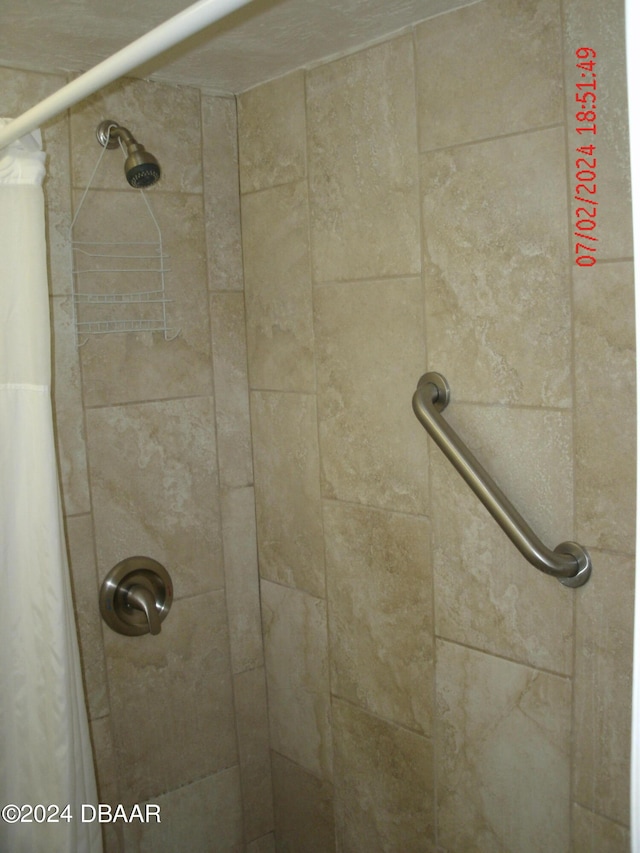 interior details featuring a tile shower