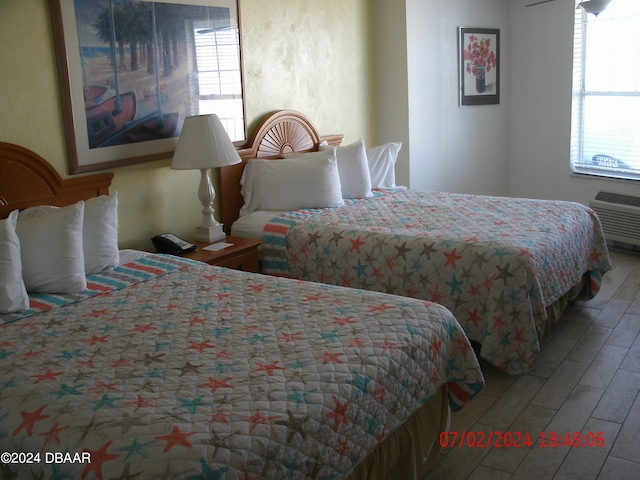 bedroom with hardwood / wood-style floors and multiple windows