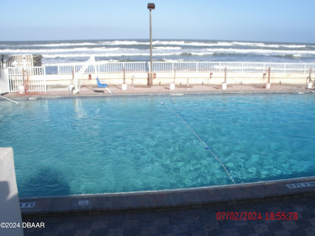 view of swimming pool featuring a water view