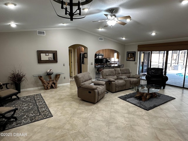 living room featuring ceiling fan, ornamental molding, and lofted ceiling