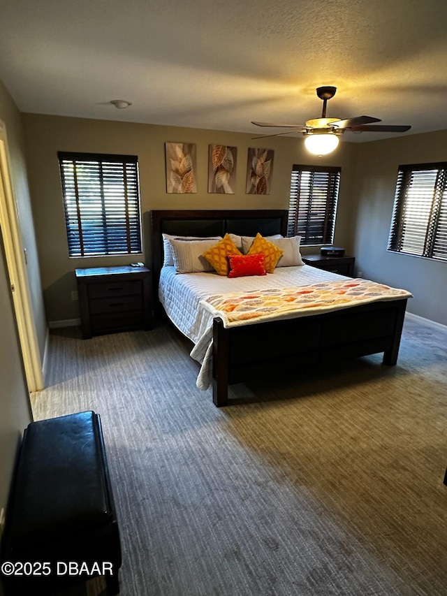 carpeted bedroom featuring ceiling fan and a textured ceiling