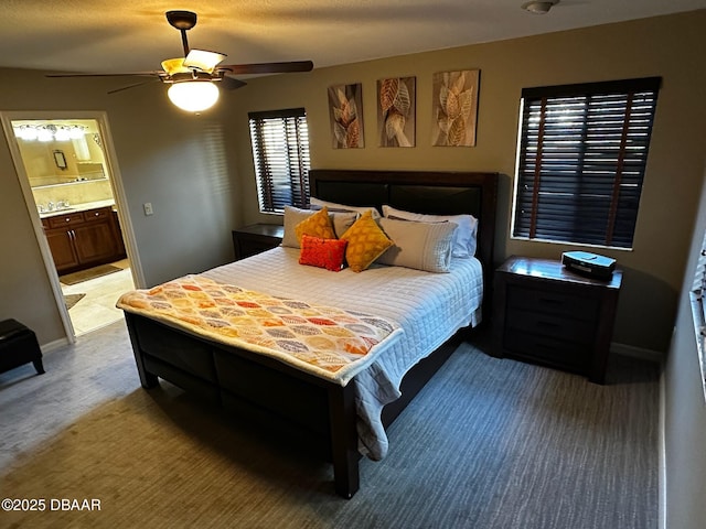 carpeted bedroom featuring ceiling fan and ensuite bath