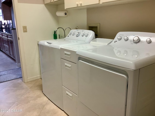 laundry room with cabinets, light tile patterned floors, and independent washer and dryer