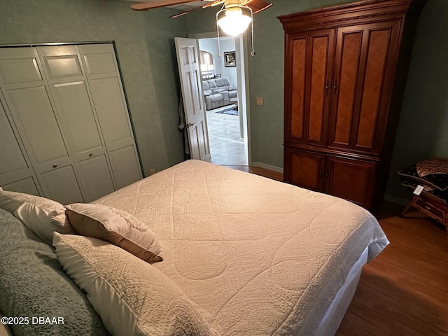 bedroom with hardwood / wood-style flooring, ceiling fan, and a closet