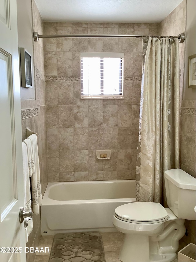 bathroom featuring tile patterned floors, toilet, and shower / bath combo with shower curtain