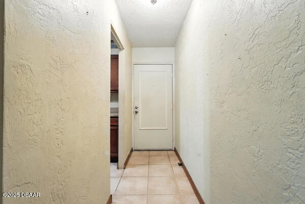 329 Wilder Blvd Unit C 201, Daytona Beach, FL 32114 - hall featuring a textured wall, light tile patterned floors, and a textured ceiling