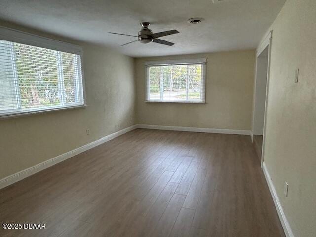 unfurnished room with ceiling fan and dark hardwood / wood-style flooring