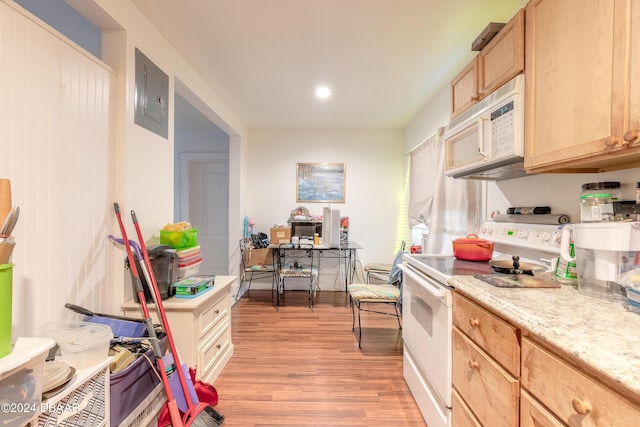 kitchen with electric panel, light brown cabinets, white appliances, and light hardwood / wood-style flooring