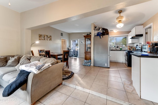 kitchen featuring light tile patterned flooring, appliances with stainless steel finishes, and white cabinets