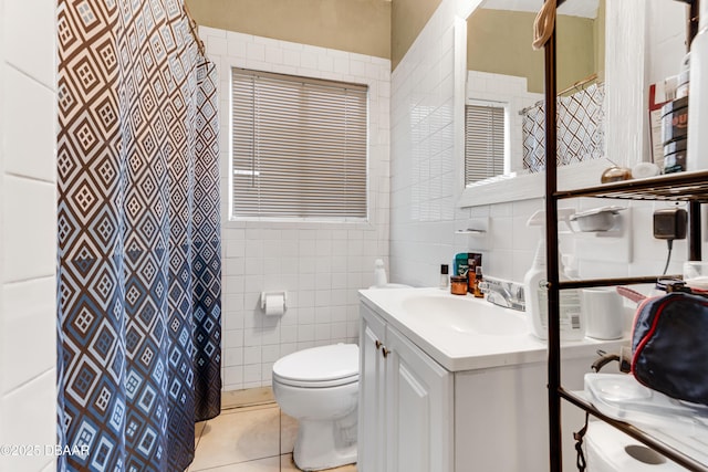 bathroom with vanity, toilet, tile patterned flooring, and tile walls