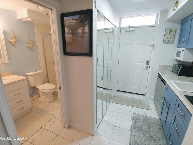 bathroom with vanity, tile patterned floors, toilet, and walk in shower