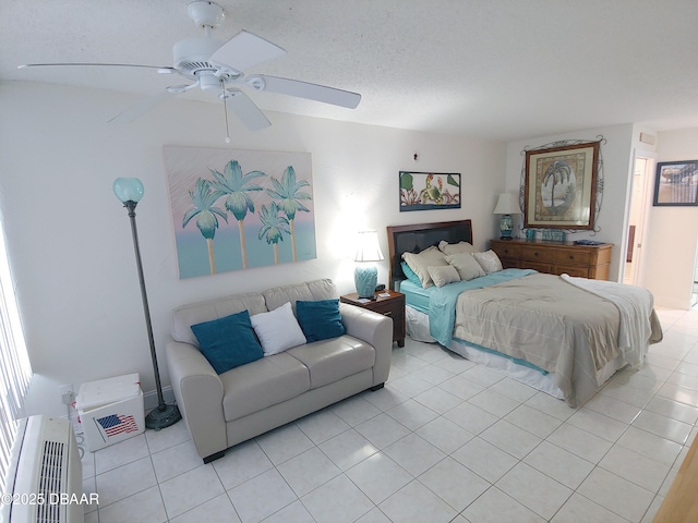 bedroom with a textured ceiling, ceiling fan, and light tile patterned flooring