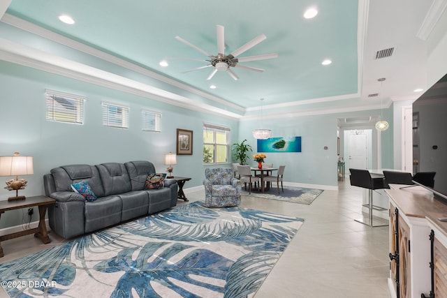 living room featuring ornamental molding, light tile patterned flooring, ceiling fan, and a tray ceiling