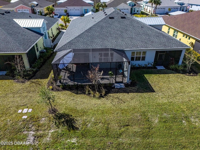 back of property with a yard and glass enclosure