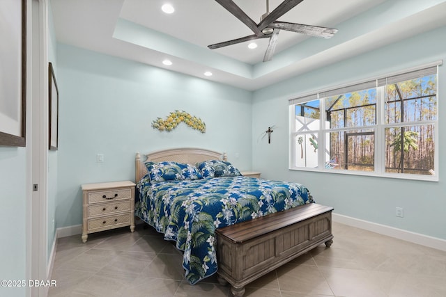 bedroom featuring light tile patterned floors, a tray ceiling, and ceiling fan