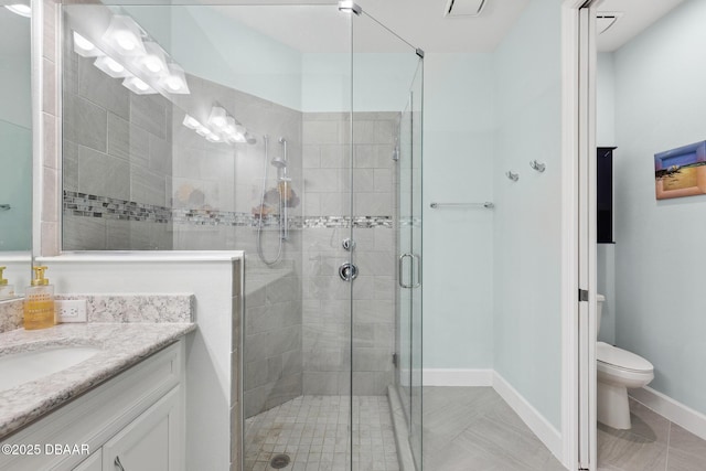 bathroom with vanity, toilet, and a shower with shower door