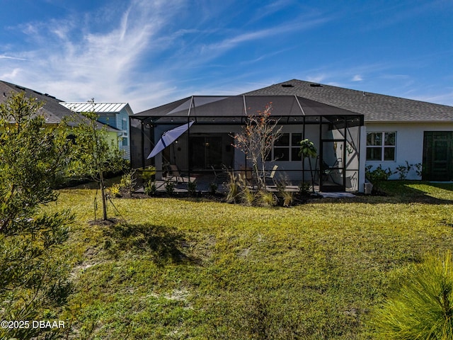 rear view of property with a lanai and a lawn