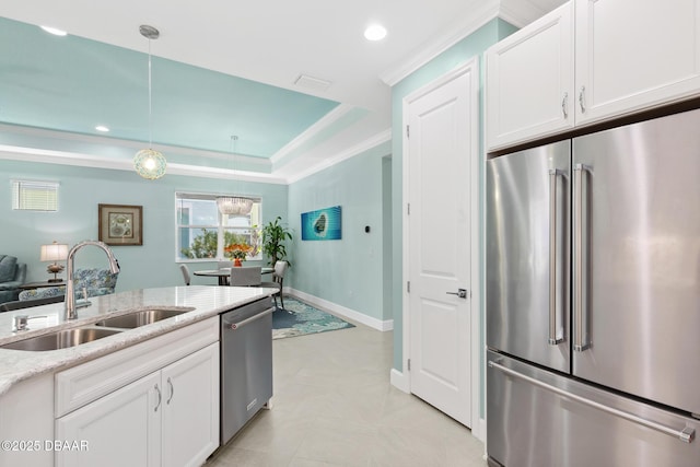 kitchen featuring white cabinetry, stainless steel appliances, decorative light fixtures, and sink