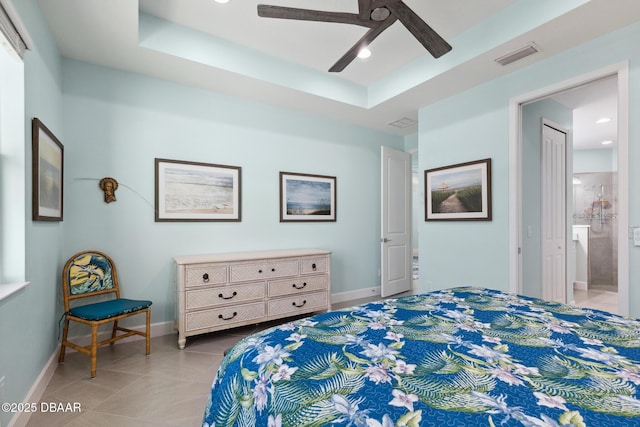 tiled bedroom featuring connected bathroom, ceiling fan, and a tray ceiling