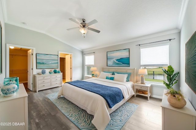 bedroom featuring a ceiling fan, vaulted ceiling, ornamental molding, and wood finished floors