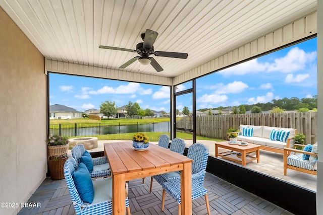 sunroom with a water view, ceiling fan, and an outdoor hangout area