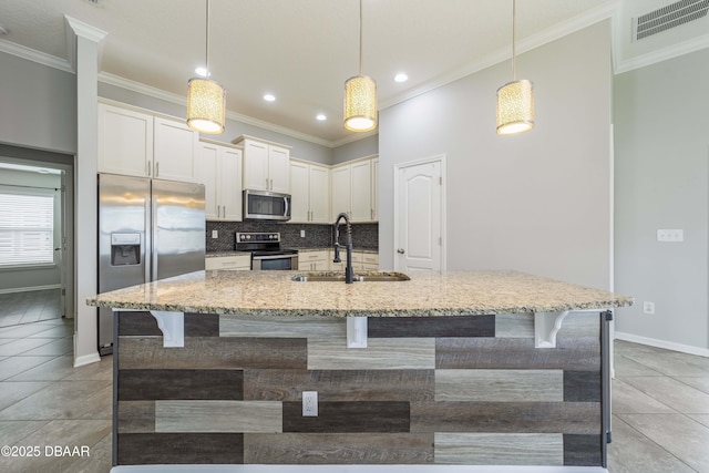 kitchen with a sink, ornamental molding, stainless steel appliances, and visible vents