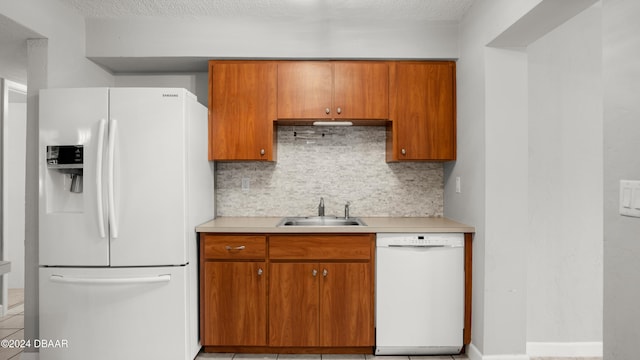 kitchen featuring a textured ceiling, tasteful backsplash, sink, light tile patterned floors, and white appliances