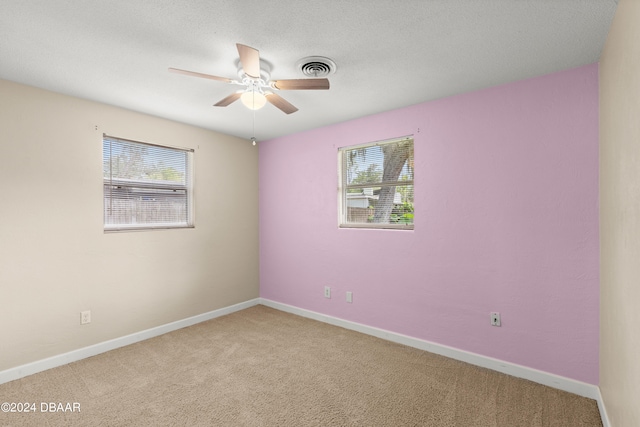 unfurnished room featuring a textured ceiling, carpet flooring, and ceiling fan