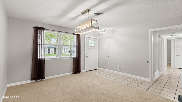 unfurnished room with a textured ceiling and light carpet