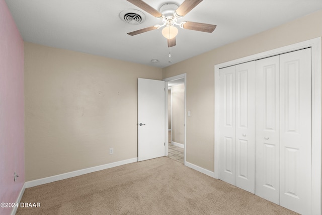 unfurnished bedroom with a closet, light carpet, and ceiling fan