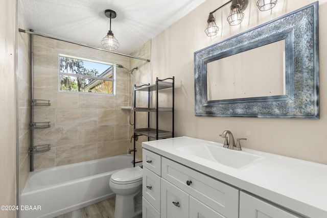 full bathroom with hardwood / wood-style floors, vanity, toilet, and tiled shower / bath