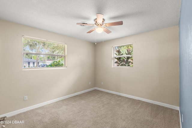 carpeted spare room featuring ceiling fan and a textured ceiling