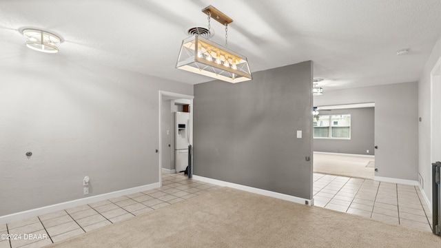 unfurnished dining area with a textured ceiling and light carpet