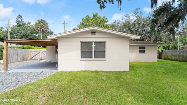 back of house with a yard and a carport