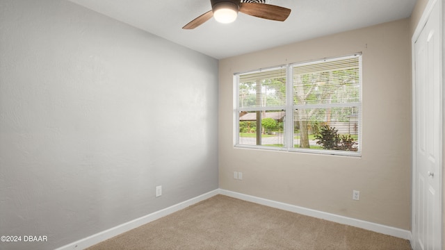 empty room with light colored carpet and ceiling fan