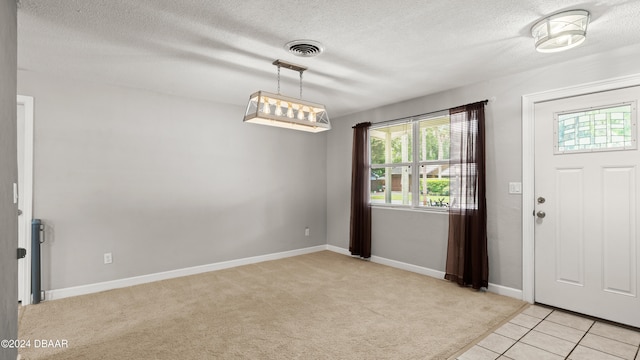 entryway with a textured ceiling and light colored carpet