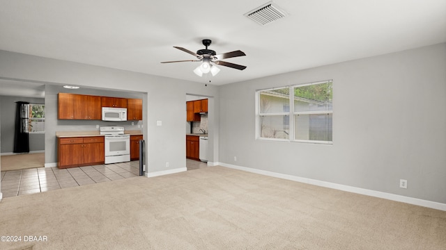 kitchen featuring white appliances, ceiling fan, and light carpet