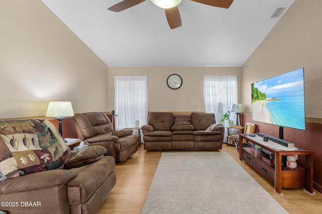 living room with lofted ceiling, ceiling fan, and light wood-type flooring