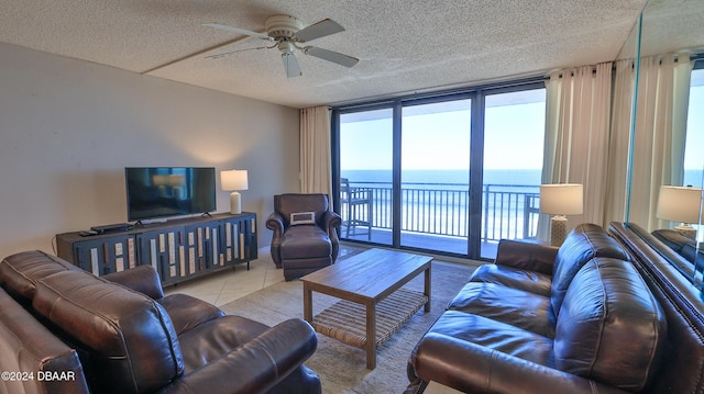 4139 S Atlantic Ave Unit A406, New Smyrna Beach, FL 32169 - tiled living area featuring a ceiling fan, a textured ceiling, and floor to ceiling windows