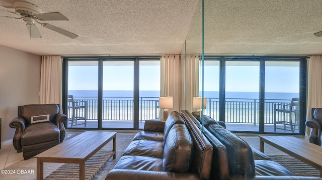 4139 S Atlantic Ave Unit A406, New Smyrna Beach, FL 32169 - living area featuring a textured ceiling, a water view, and ceiling fan