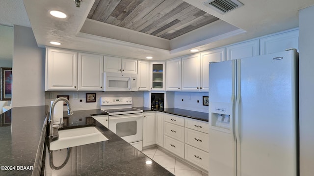 4139 S Atlantic Ave Unit A406, New Smyrna Beach, FL 32169 - kitchen featuring white appliances, a raised ceiling, white cabinets, dark stone countertops, and recessed lighting