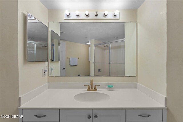 bathroom with a shower with door and vanity