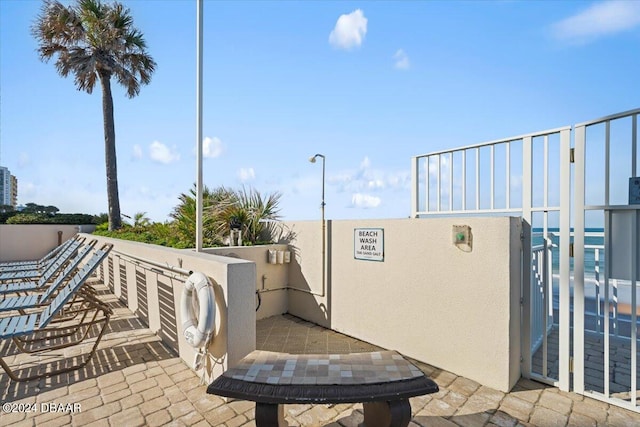 view of patio with a water view and a balcony