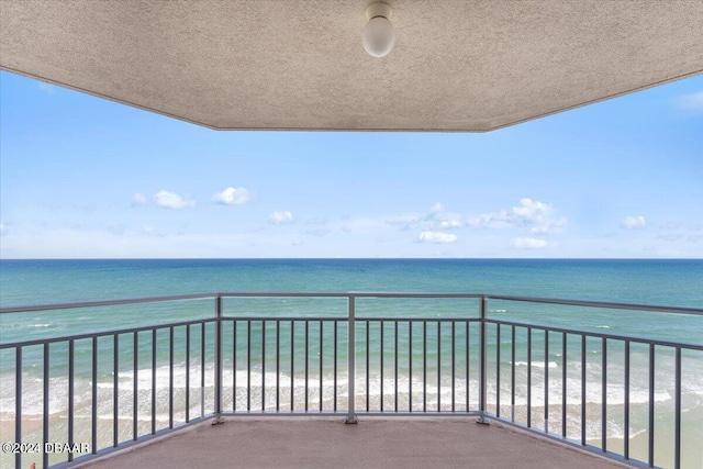 balcony featuring a water view and a beach view