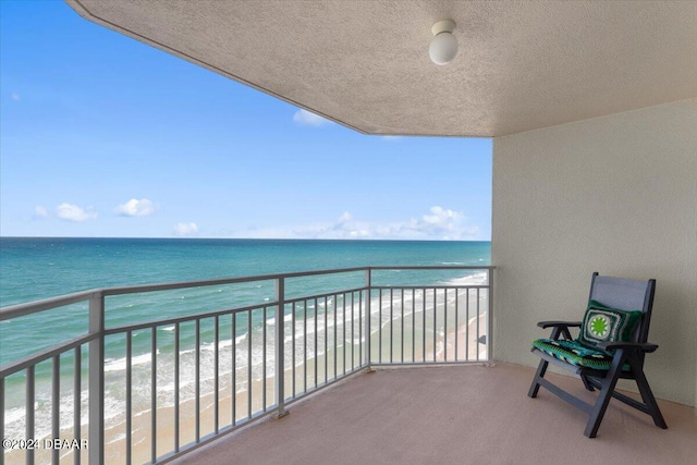 balcony with a water view and a beach view